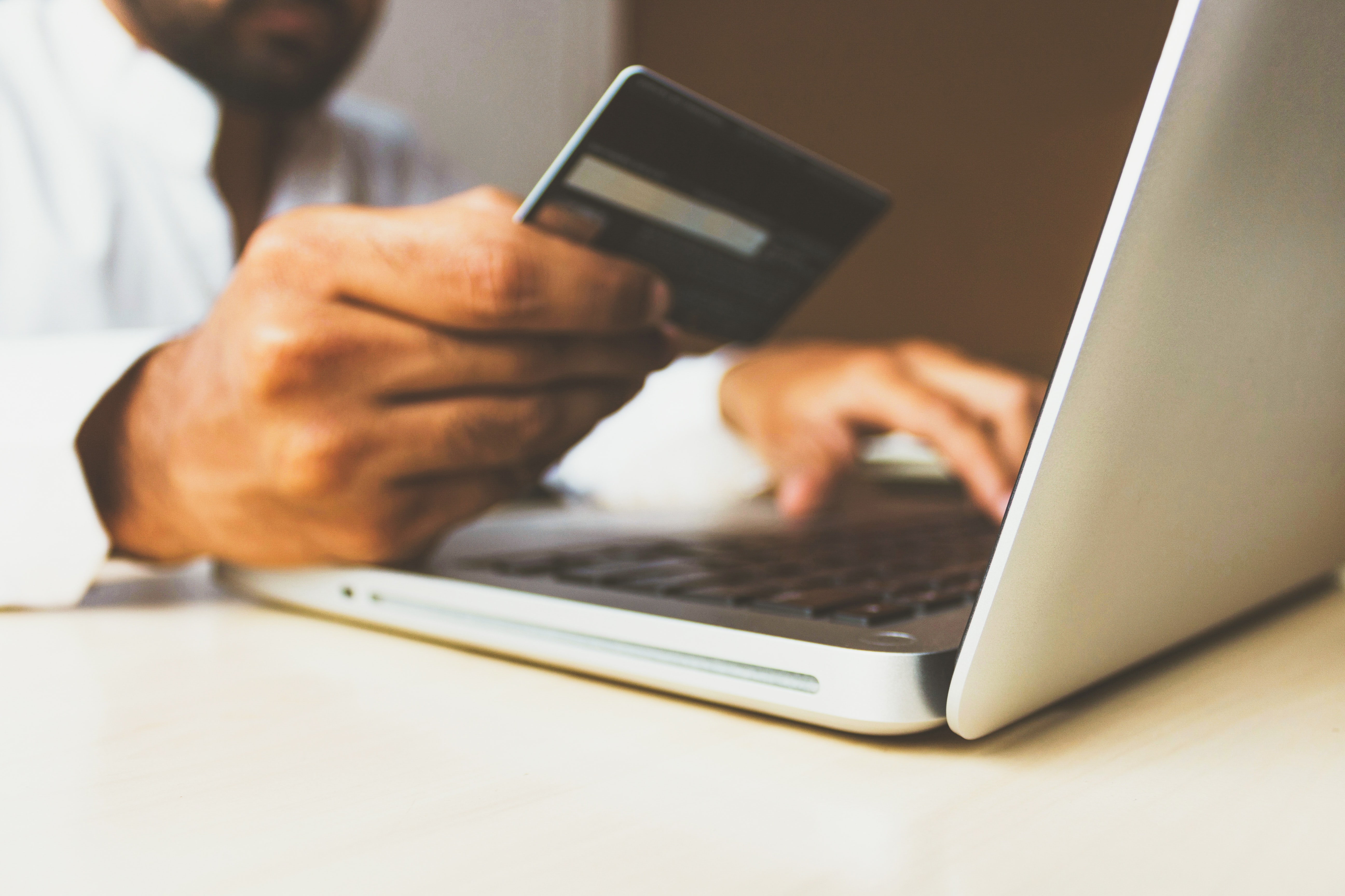 Low transfer fees is an important criteria when selecting a market for investment Man behind a laptop with a credit card