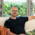 None A handsome man sitting on a couch.