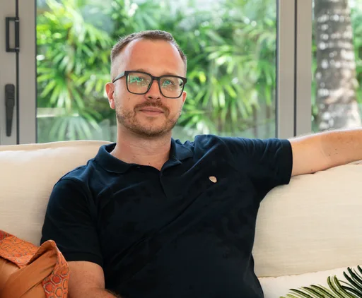 A handsome man sitting on a couch.